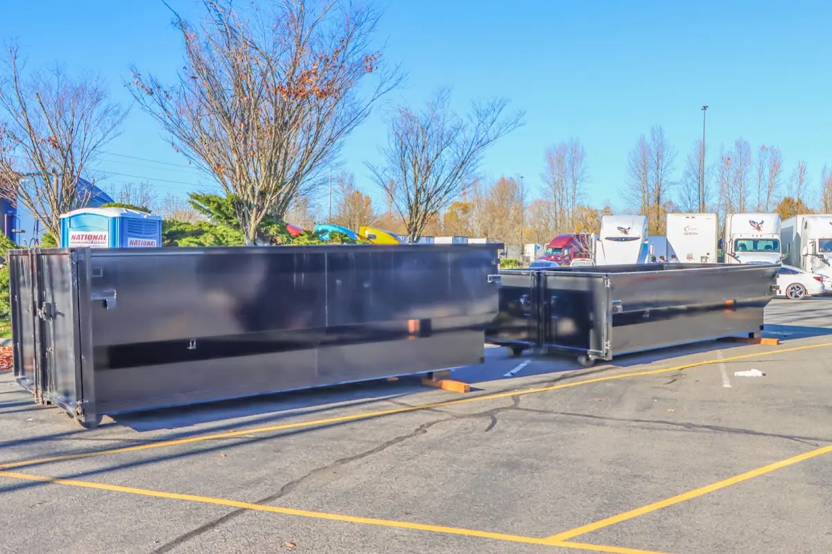 Professional dumpster rental service with roll-off container on residential driveway in Ayden